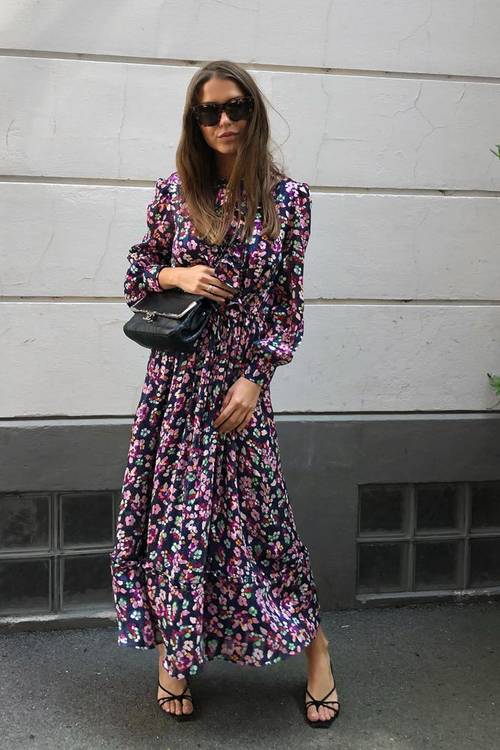 a dark floral maxi dress with long sleeves and a high neckline, a black bag and black strappy kitten heels