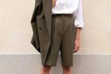 a graphite grey short suit with an oversized blazer, Bermuda shorts, a white shirt and black sandals