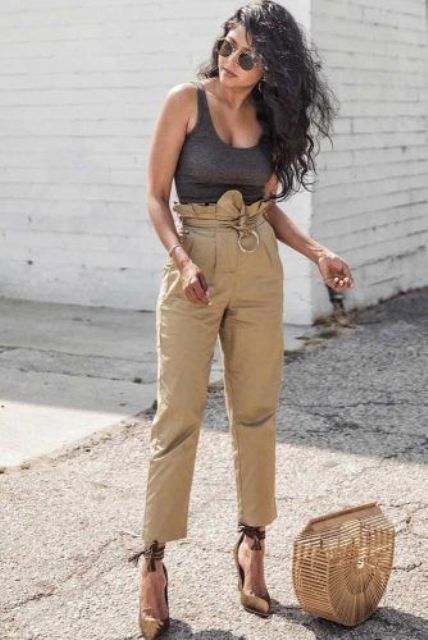 a grey thick strap top, tan paperbag waist pants, ankle bow heels and a wooden bag