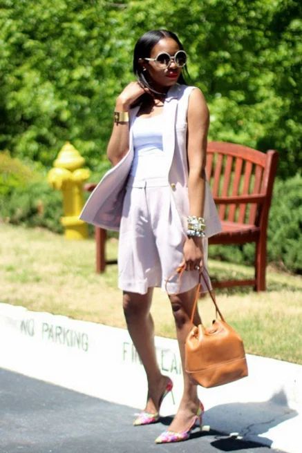 a lilac waistcoat and bermuda shorts, pink printed shoes, a white top and a brown bag