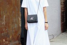 a minimalist summer outfit with a white midi t-shirt dress with a high neckline, short sleeves and an asymmetrical skirt, black slingbacks and a black bag