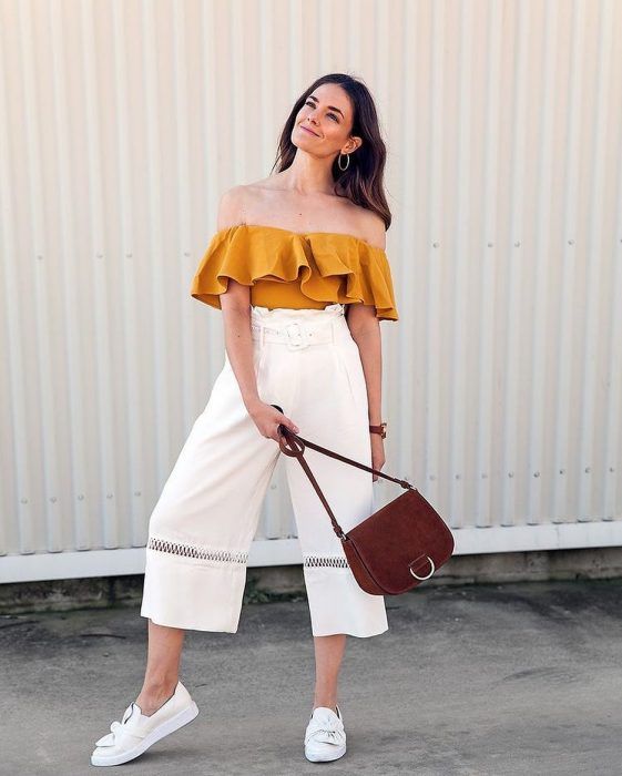 a mustard ruffle off the shoulder top, high waisted culottes, white moccasins and a plum colored bag