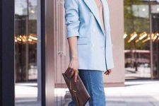 a nude top, blue jeans, an oversized blue blazer, snakeskin print mules and a brown clutch