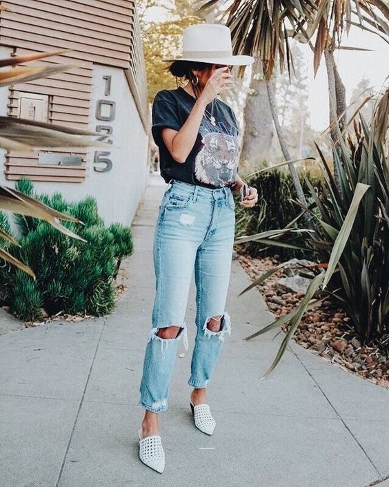 a printed tee, blue ripped jeas, white mules, layered necklaces and a hat for a brunch