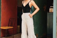 a retro-inspired look with a black bodysuit, striped flare pants, colorful platform heels