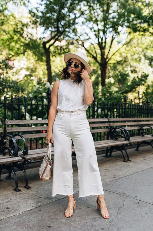 a white sleeveless crochet top, white wideleg pants, nude block heels, a neutral hat and a bag