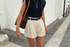 ivory pleated mini shorts, a top with accented shoulders, nude sandals and a dark bag plus layered necklaces