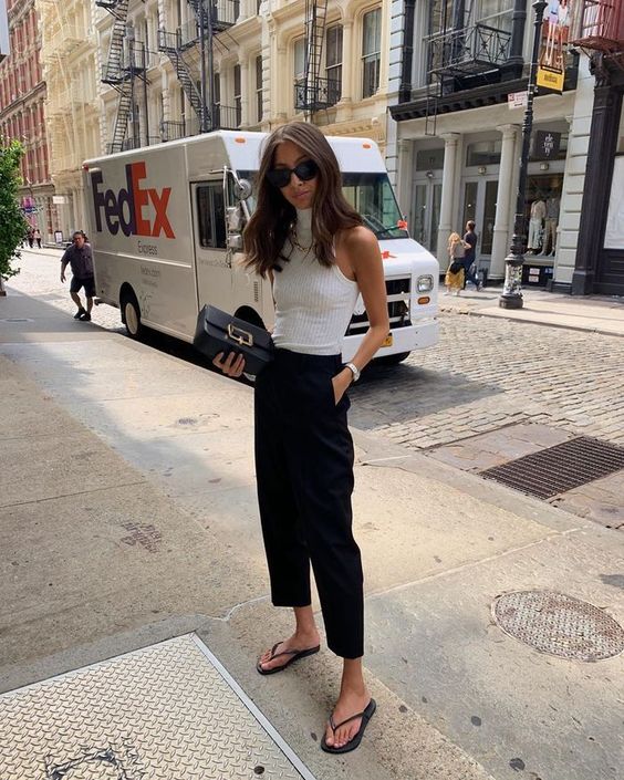 a white turtleneck top, black cropped trousers, a black clutch and black flipflops are a chic idea