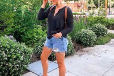 With black loose shirt, brown leather bag and distressed denim shorts