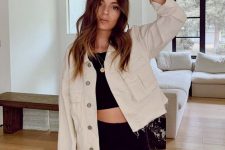 a black crop top and biker shorts, a tan cropped denim jacket and sunglasses