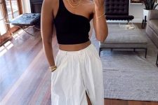 a black one shoulder crop top, a white linen midi skirt, white sneakers and layered necklaces for a lovely look