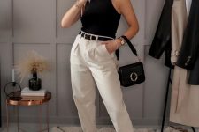 a black sleeveless top, white trousers, a black belt, black dad sandals, a black bag with a ring for a super elegant look