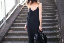 a black slip midi dress, black birkenstocks, a bag and a hat for a chic and bold summer look