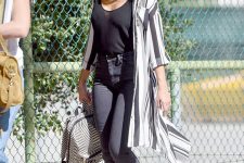 a black top, grey jeans, black birkenstocks, a striped kimono and a black and white backpack compose a chic look