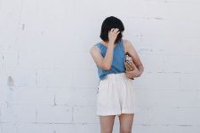 a blue linen top, neutral linen shorts, nude mules, a wooden bag are all you need in a heat wave