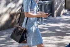 a blue printed over the knee dress with short sleeves, white sneakers and a black bag for summer