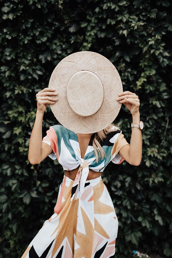a breezy and light two piece summer dress with a tied crop top with short sleeves anda midi skirt, a hat