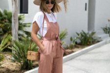 a breezy vacation look with a white tee, a mauve linen overall, brown slippers, a woven bag and a hat