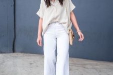a cool linen work outfit with a loose neutral shirt with short sleeves, white cropped linen pants, neutral heels and a bag