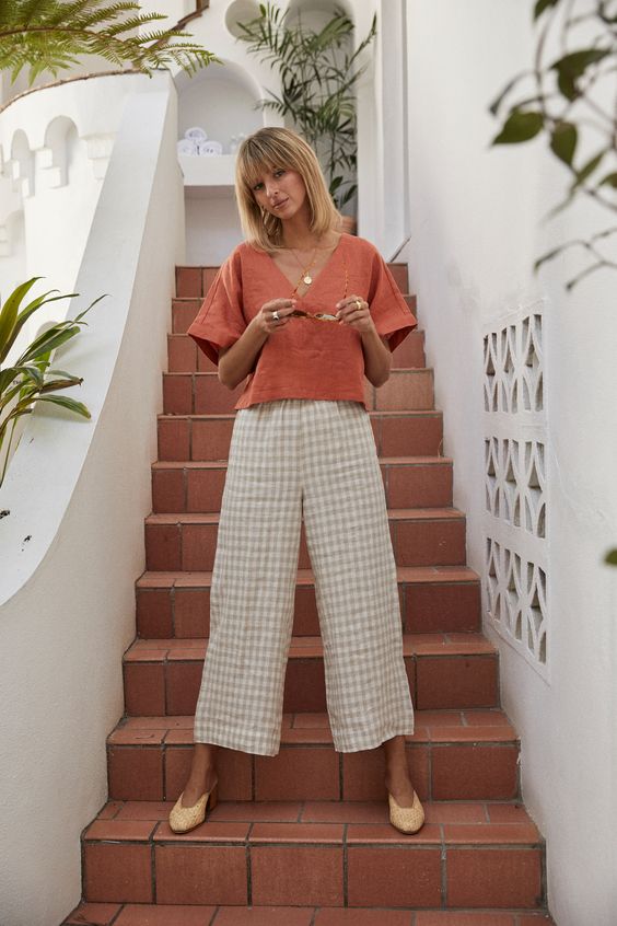 a creative vacation look with an orange oversized linen top and gingham pants, yellow mules for summer