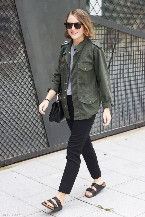 a grey top, black trousers, black birkenstocks, a black bag and a green army jacket for a stylish summer work look