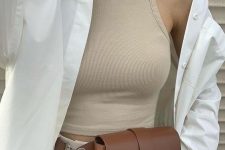 a modern minimalist look with a tan crop top, neutral high waisted trousers, a white shirt, a brown belt bag