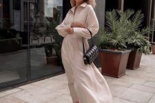 a neutral maxi shirtdress with long sleeves, a black bag and black dad sandals for a super chic and bold summer look
