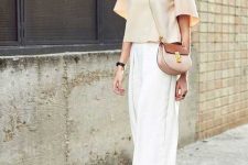 a neutral summer work look with a tan oversized top with short sleeves, white culottes, nude block heels and a two tone bag