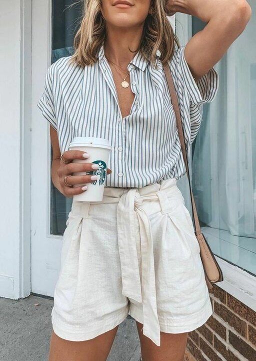 a pinstripe shirt with short sleeves, neutral linen shorts, a tan bag and layered necklaces for a hot working day