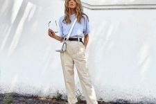 a simple and comfy linen summer work look with a blue t-shirt, neutral pants, white slipper mules, a black belt and a white bag