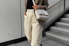 a stylish summer work outfit with a black top, creamy jeans, black dad sandals, a grey oversized blazer and a white bag