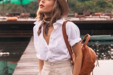 a summer vacation look with a white linen shirt, neutral high waisted Bermudas, a hat, a neck tie and a brown backpack