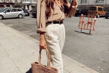 a summer work look with a tan linen shirt, white trousers, black moccasins and a brown woven bag