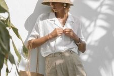 a vacation look with a white linen shirt, grey linen Bermudas, a hat, a woven bag and statement earrings