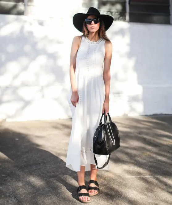 a white boho lace midi dress with no sleeves, black birkenstocks, a black bag and a hat for an ultimate look
