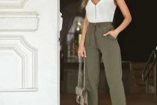 a white button up spaghetti strap top, olive green pants, nude heels and a neutral printed bag