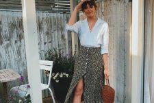 a white linen shirt, a black printed button up midi skirt, brown strappy shoes and a basket bag