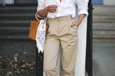 a white linen shirt, tan linen trousers, espadrilles and an amber bucket bag with round handles