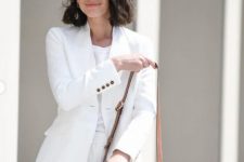 a white linen suit with shorts, a white top and a brown bag for an elegant summer work look