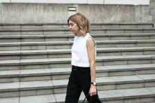 a white sleeveless top, black trousers and a belt, black birkenstocks and a black bag is a cool minimalist look