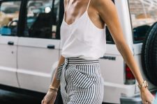a white spaghetti strap top, high waisted striped flare pants and a small neutral bag for a hot summer day