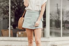a white striped linen shirt, a blue wrap mini bag, white sneakers and a round woven bag plus statement sunglasses for a chic look