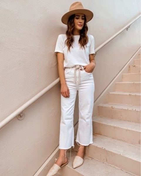 a white t-shirt, white jeans with a raw hem, neutral mules, a hat and a woven sash