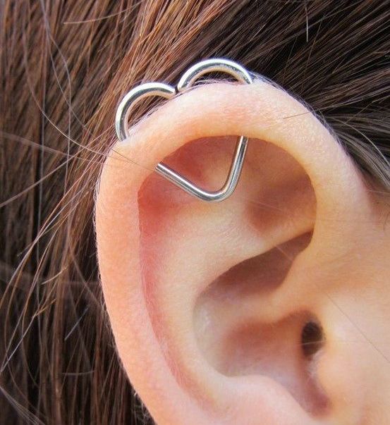 an orbital piercing done with a large heart earring is a creative idea to add a bit of cuteness to your look