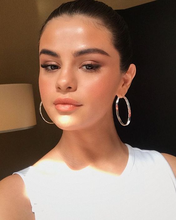 Selena Gomez wearing silver finish statement hoop earrings looks gorgeous, modern and fresh