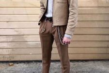 14 a bold and cool look with a grey turtleneck, brown pants, a brown shirt jacket, white sneakers and various accessories
