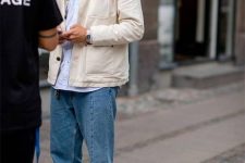 18 a simple look with a white shirt, a creamy jacket, blue jeans, black sneakers is timeless classics