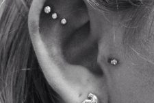 19 chic ear styling with a triple flat, a tragus and a lobe piercing, with matching rhinestone studs and a bird stud
