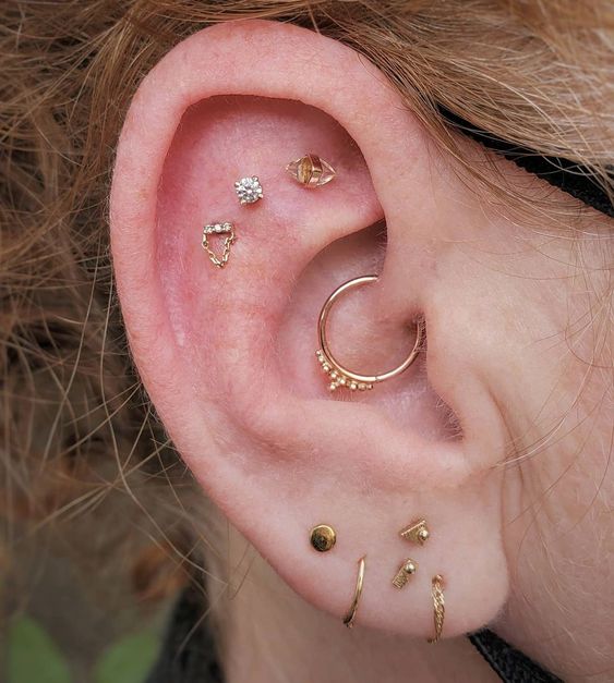 creative stacked piercings - stacked lobe ones, a daith and a triple flat piercing are a lovely idea for a modern girl