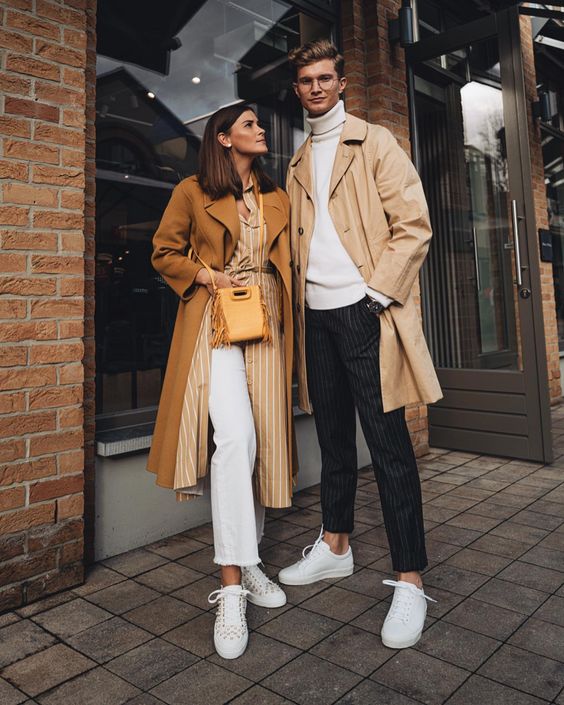 a chic outfit with a white turtleneck, thin stripe pants, white sneakers, a tan trench is very elegant